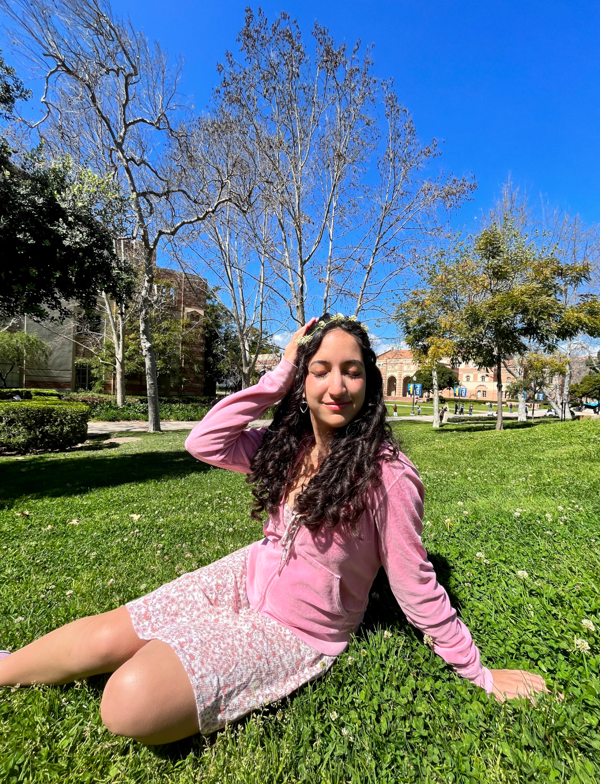 Hedieh Hemati (author) sitting on the grass outside during a sunny day. 